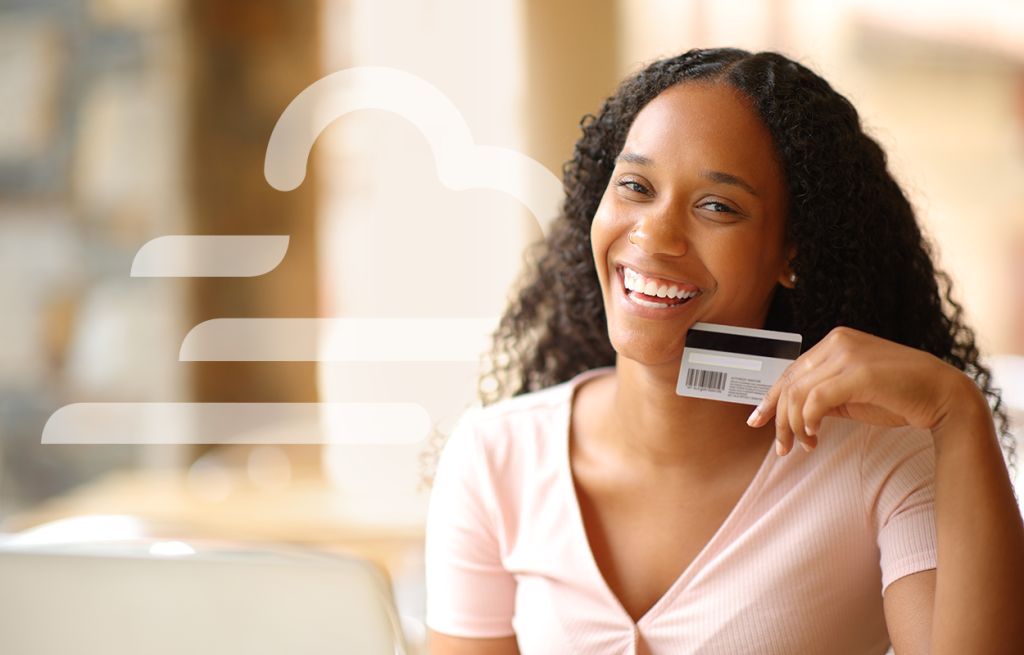 Woman smiling and holding a payment card, with a stylized cloud graphic overlaid on the left.